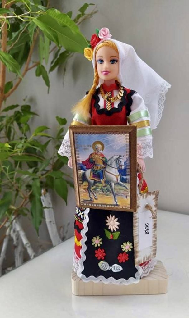 Жена в българска народна носия с икона в ръце